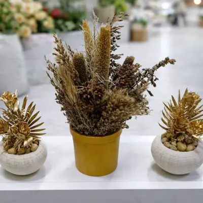 Composition décorative florale dorée avec fleurs séchées et pots design